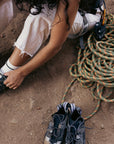 WILD Kai Preparing To Climb while changing from anatomical barefoot hiking approach shoes with climbing rope and outdoor gear nearby