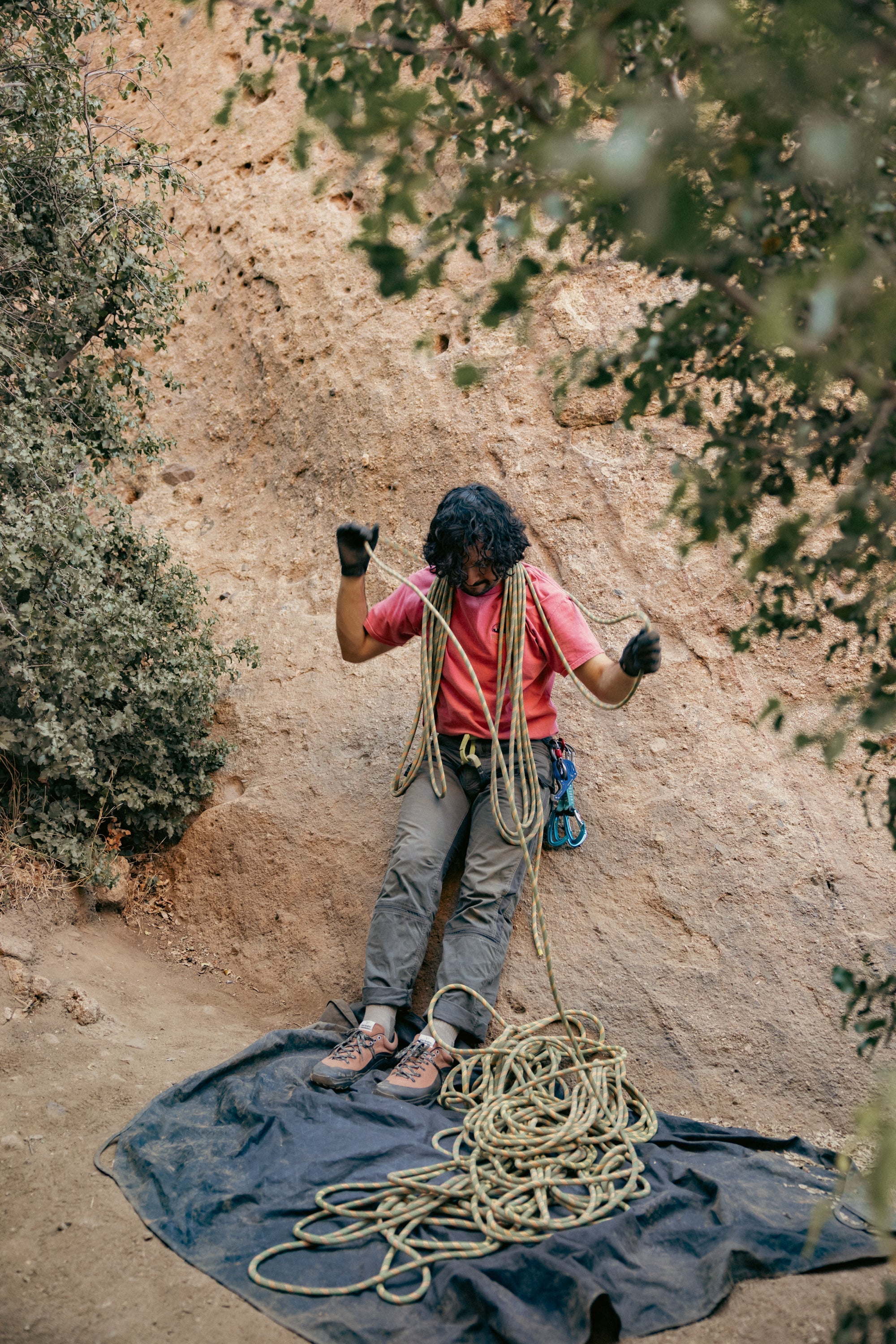 WILD Dirt worn by a climber handling rope with zero drop outdoor grippy outsole and adventurous aesthetic standing on a rocky climbing spot